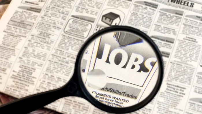 Lupa pusă pe cuvântul Jobs dintr-un ziar