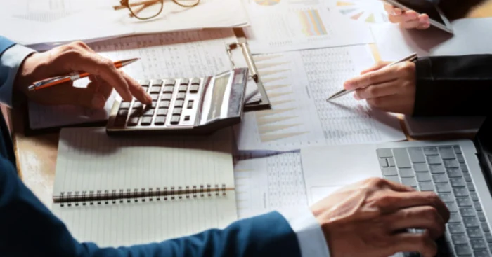 Doi oameni calculează ratele la un credit de nevoi personale